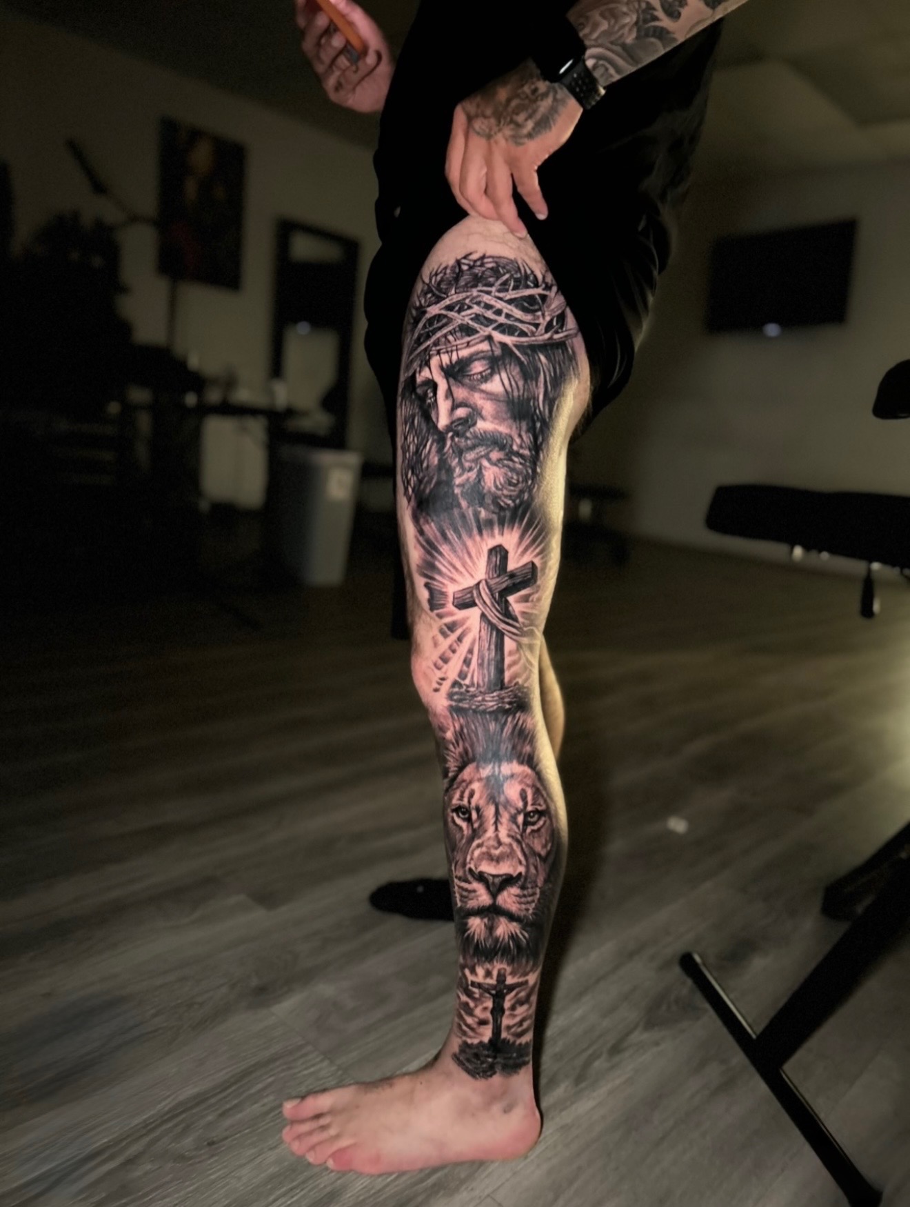 Black and grey Jesus and lion leg sleeve tattoo